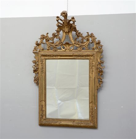 Specchiera rettangolare in legno dorato con cimasa riccamente intagliata e...