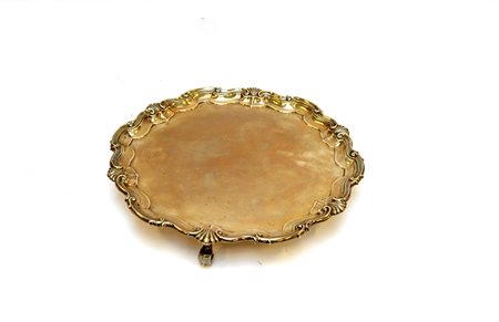 Salver in argento di forma circolare mistilinea, bordo decorato con volute e...