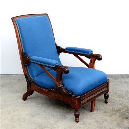 Poltrona con schienale reclinabile in noce con braccioli e montanti sagomati...