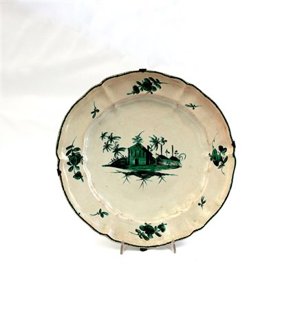 Piatto tondo polilobato in maiolica decorato con il motivo 'a paesino in...