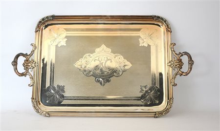 Grande vassoio biansato in metallo argentato inciso nel cavetto a volute e cifre