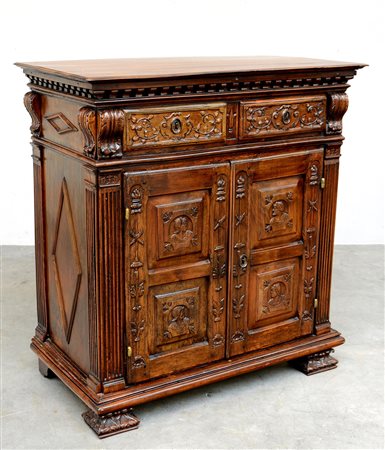 Credenza a due ante e due cassetti intagliati a rami fioriti e mascheroni,...