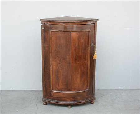 Angoliera in noce ad un'anta curva sul fronte. Piedi torniti (cm 69x105x45)