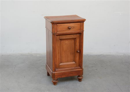 Comodino in noce ad un cassetto sottopiano e antina sul fronte. Piedi...