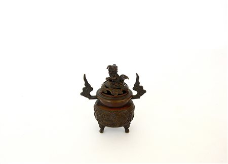 Piccolo incensiere biansato in bronzo decorato con fenici e sormontato da...