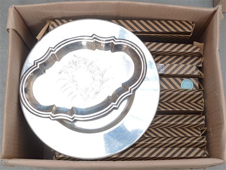 Cartone contenente undici sottopiatti in acciaio e un vassoietto