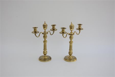 Coppia di candelieri a tre fiamme in ottone decorato a motivi stilizzati....