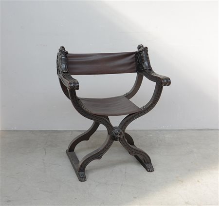 Poltrona "savonarola" con braccioli sagomati e intagliati con figura...