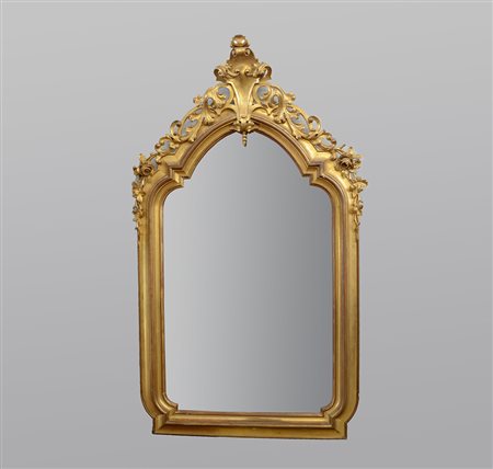 Specchiera in legno dorato con cimasa applicata,scolpita e intagliata, di...