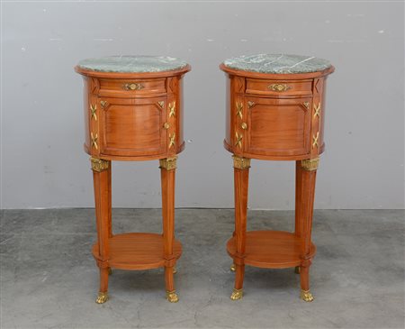 Coppia di comodini tondi di gusto Impero in legno chiaro con applicazioni in...