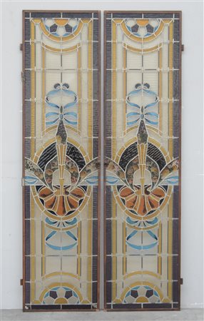 Coppia di vetrate policrome con vetri legati a piombo, decorate con fiocchi e...