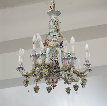 Manifattura italiana. Lampadario a dosici luci in ceramica policroma decorato...