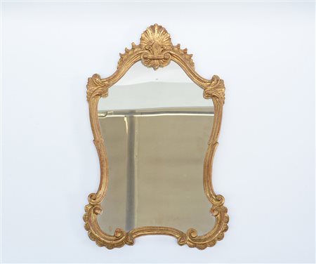 Specchierina di forma sagomata in legno dorato, intagliata a motivi vegetali...