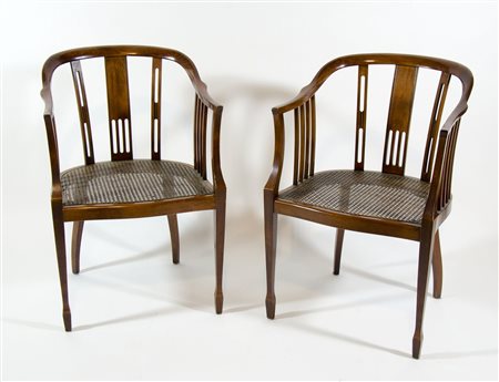 Coppia di poltroncine a pozzetto con schienale intagliato.