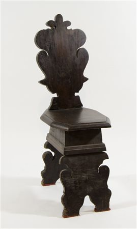 Sedia con alto schienale in legno scolpito.