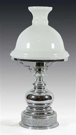 Lampada da tavolo in metallo cromato con paralume in vetro opalino. H. cm. 68.