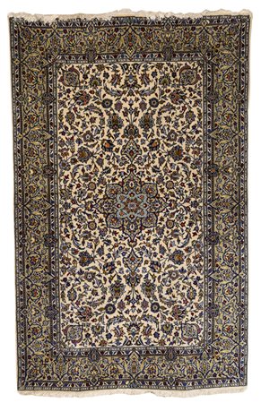 Tappeto a fondo beige, decorato a motivi floreali nei toni dell'azzurro, blu...