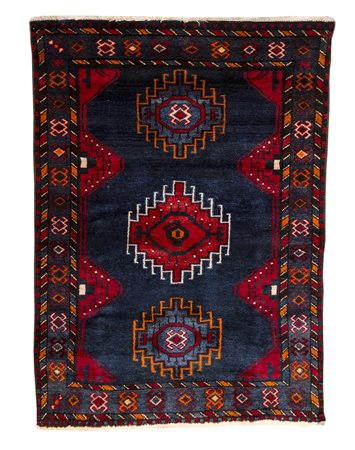 Tappeto a fondo blu, decorato a motivi geometrici nei toni del rosso blu e...