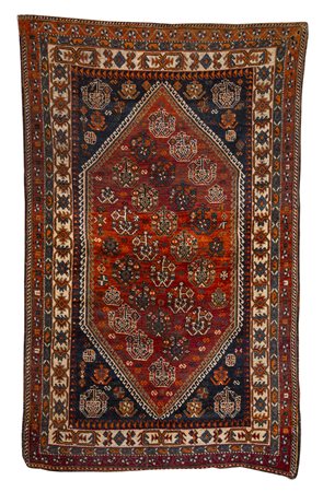 Tappeto a fondo nero, decorato a motivi geometrici nei toni del rosso,...