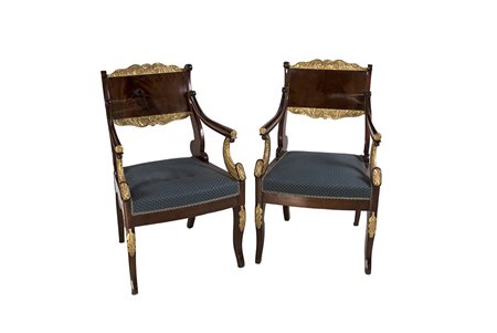 Coppia di poltrone in piuma di mogano, impreziosite da rilievi decorativi...