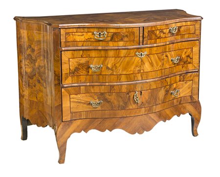 Cassettone impiallacciato in radica di noce; corpo sagomato con pannelli...