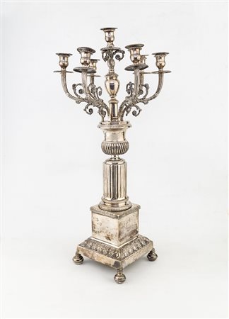 Candelabro in argento a sette luci che si dipartono da un supporto a forma di...