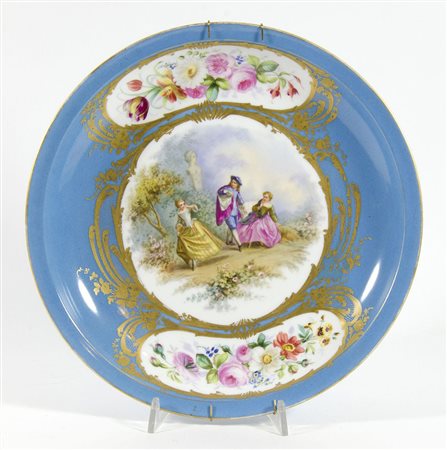 Piatto in porcellana policroma con al centro scena galante. Inizio XX secolo....