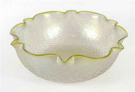 Grande ciotola in vetro iridescente con bordo ondulato. Etichetta parziale...