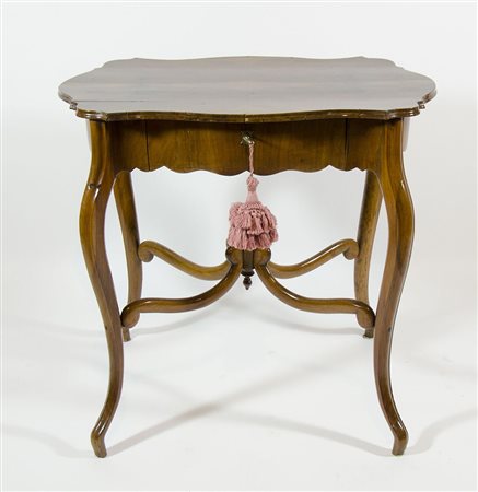 Tavolino da centro con bordo ondulato, su alte gambe a sciabola.