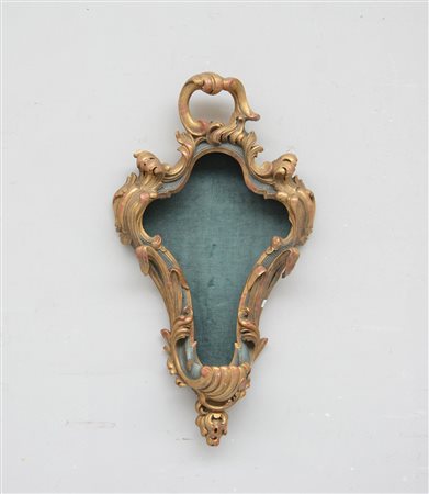 Teca di forma sagomata in legno dorato intagliata e traforata a motivi...