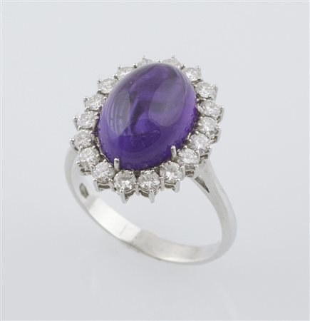 Anello in oro bianco a margherita centrato da ametista ovale taglio cabochon,...