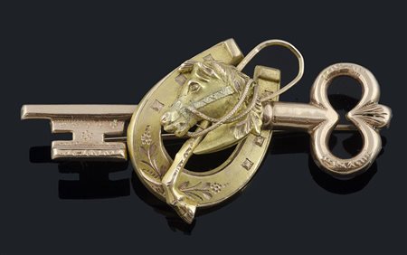 Spilla a forma di chiave in oro rosa con al centro ferro e testa di cavallo...