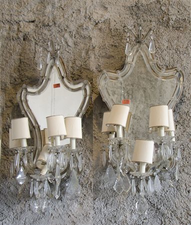 Coppia di specchiere-appliques a 5 luci in vetro di forma sagomata. H. cm. 84.