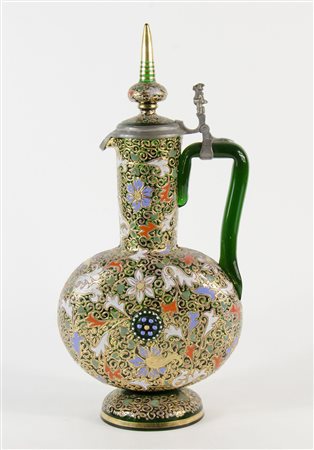 Grande brocca in vetro interamente ricoperta da smalti policromi, con manico...