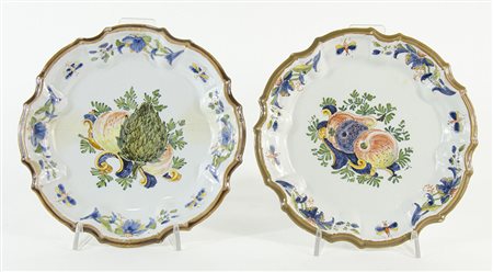 Coppia di grandi piatti in maiolica a smalti policromi con decori floreali....
