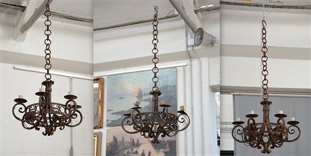 Gruppo di tre lampadari in ferro battuto a sei fiamme, fascia traforata a...