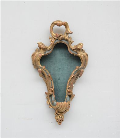 Teca di forma sagomata in legno dorato intagliata e traforata a motivi...