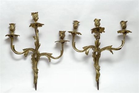Coppia di appliques in metallo dorato a tre luci, cm, 40.