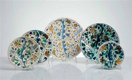 Gruppo composto da quattro piatti in maiolica policroma con ornati alla...
