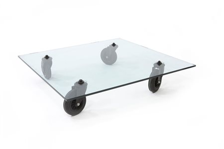 AULENTI GAE Tavolino con piano in cristallo a ruote piroettanti. cm...