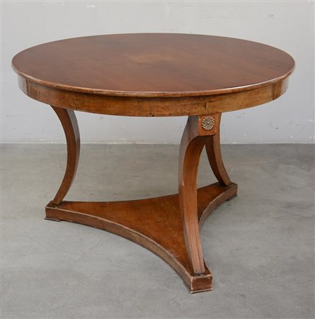 Tavolo tondo a tre gambe curve poggianti su base sagomata, fregi in metallo...