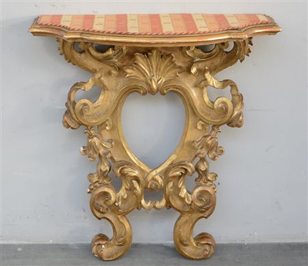 Cornice di forma sagomata in legno scolpito e dorato a volute, motivi...