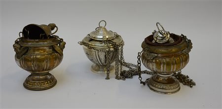Lotto composto da tre turiboli in metallo di cui due decorati con teste di...