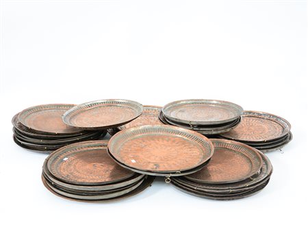 Lotto composto da trentadue piatti orientali in metallo e rame inciso, decori...