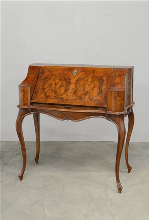 Ribalta di forma mossa lastronata in radica di noce ad un'anta sul fronte...