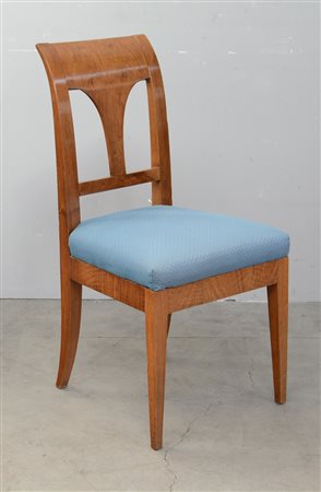 Sedia con schienale a giorno e cartella sagomata. Gambe rastremate