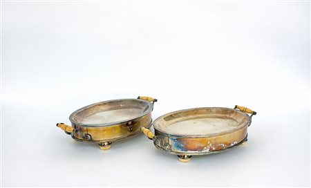 Coppia di scaldavivande di forma ovale in rame argentato con manici e piedini...