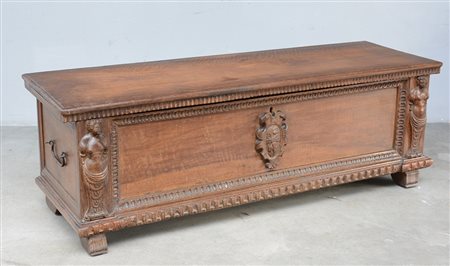 Cassone in legno intagliato e scolpito con fronte centrato da stemma e figure...