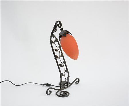 Lampada con paralume in vetro arancione e struttura in ferro. Produzione...