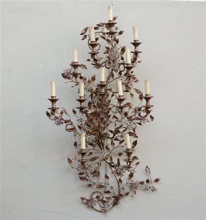 Applique a dodici fiamme in metallo argentato decorata a racemi e fiori e...